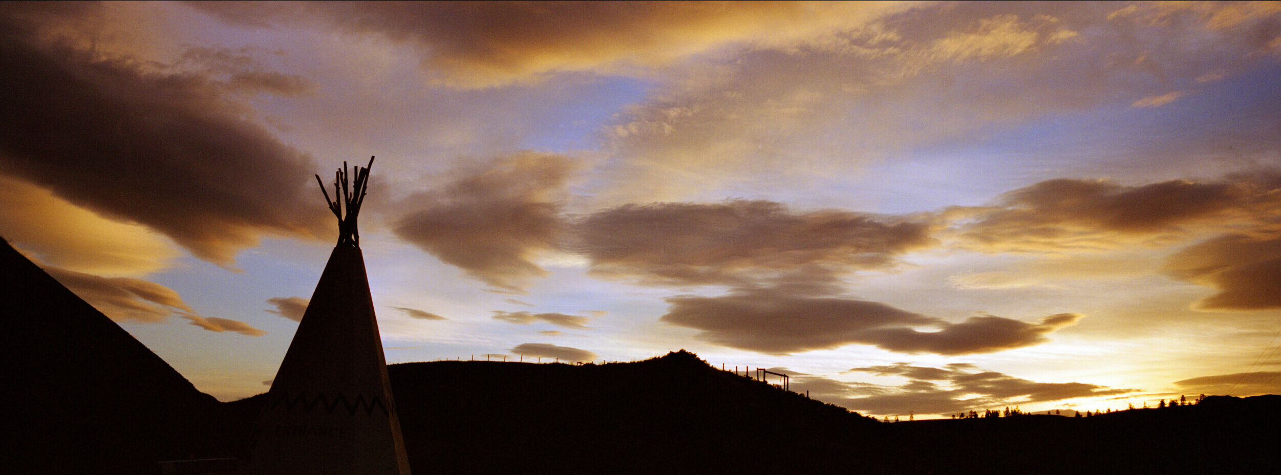 Aboriginal Laws Governance - Teepee surrounded by hills and a sunset