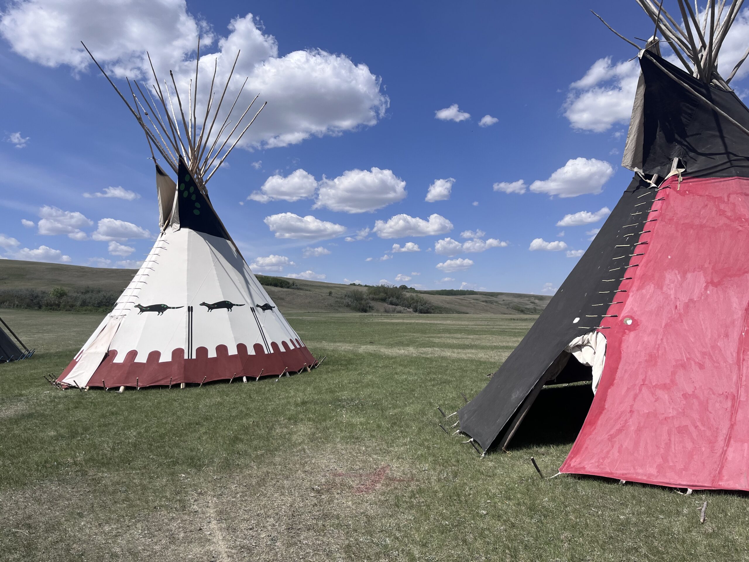 Child Protection Family - Indigenous Teepee on grass and cloudy skies