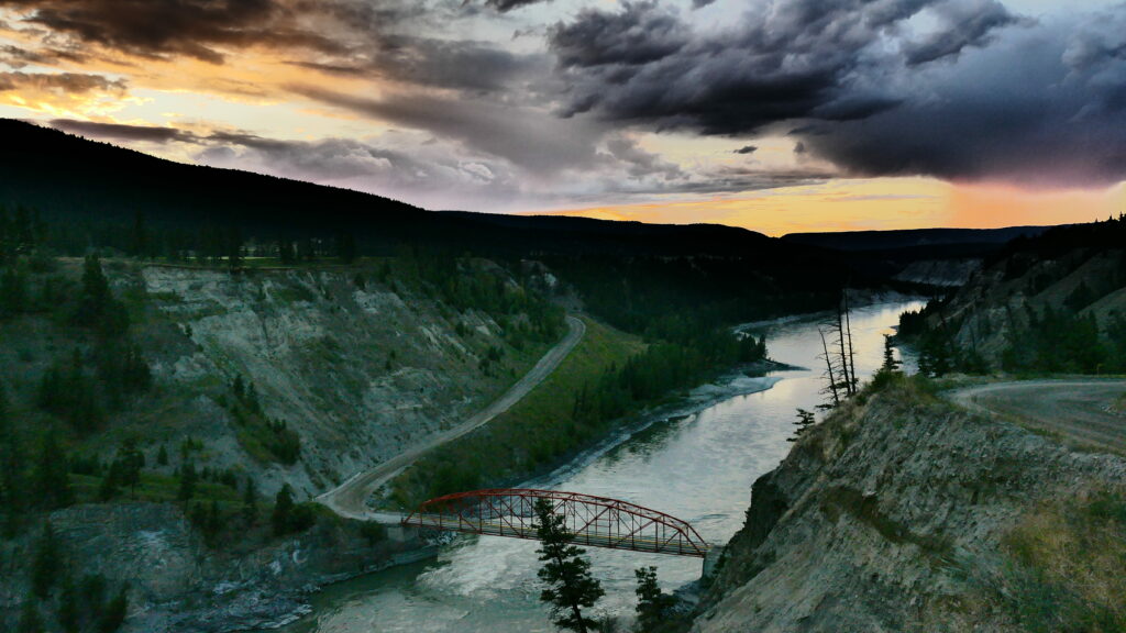 Sunset over canyon, bridge spans a river at the bottom